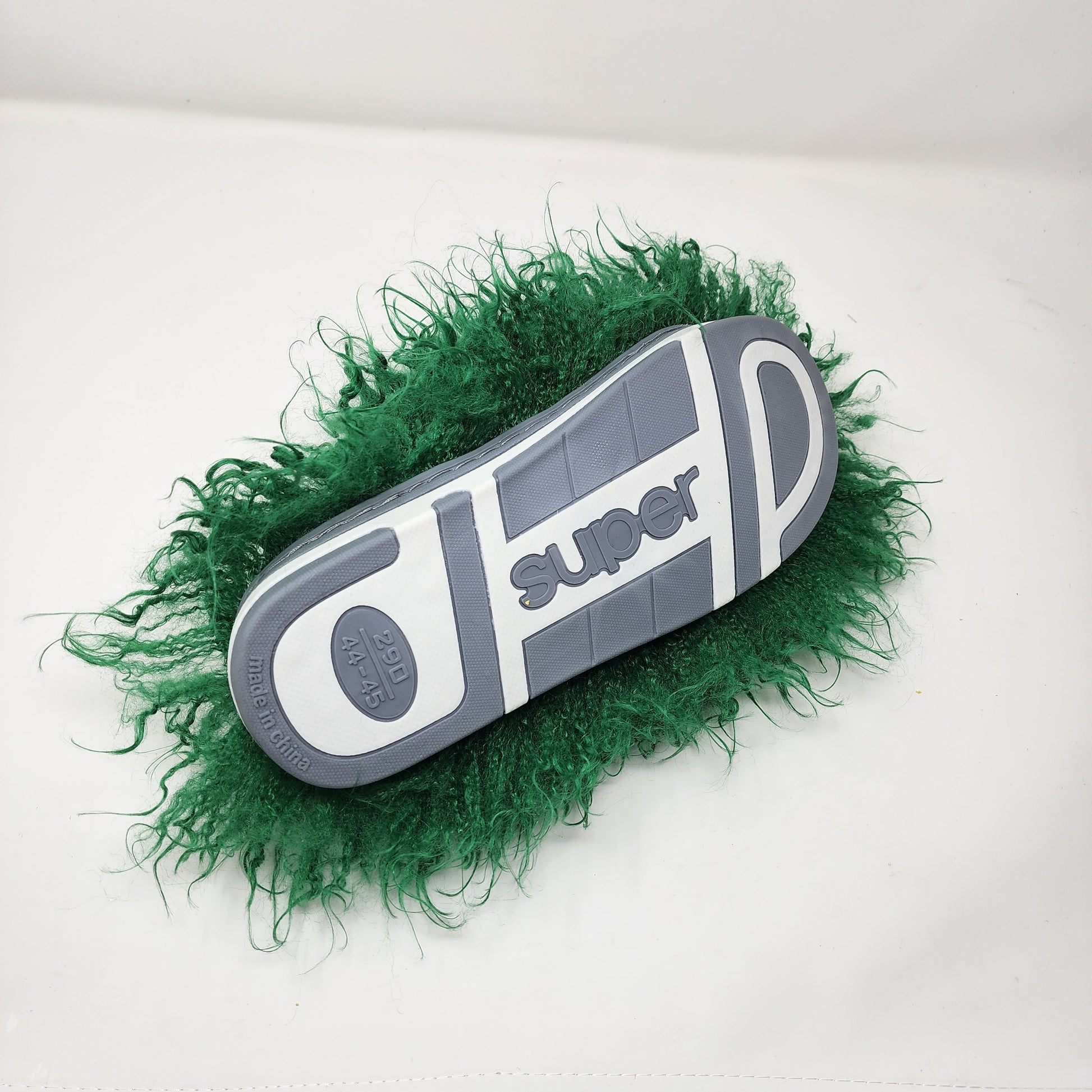 Gray shoe sole with 'super' branding on a green grass-like surface