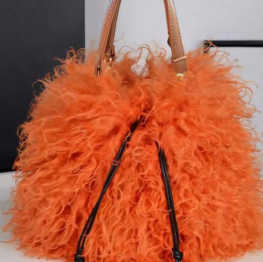 Orange fluffy handbag with a strap on a white background