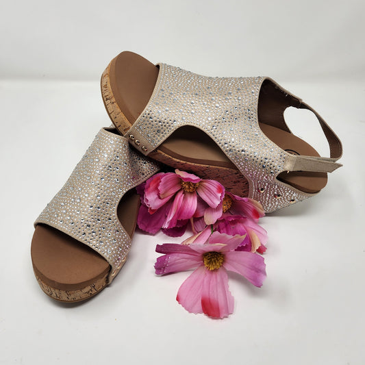 Pair of sparkly sandals with pink flowers on a light background