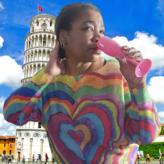 Woman in a colorful sweater blowing a pink balloon with the Leaning Tower of Pisa in the background