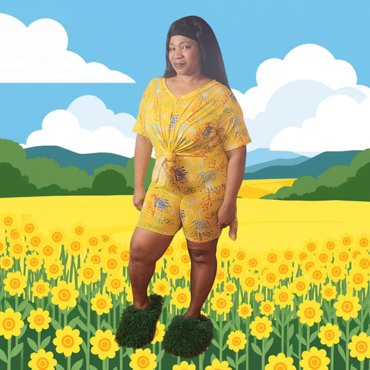 Woman in a yellow outfit standing in a field of yellow flowers with a blue sky and green hills in the background.