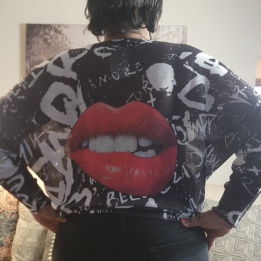 Person wearing a black sweater with red lips design on the back